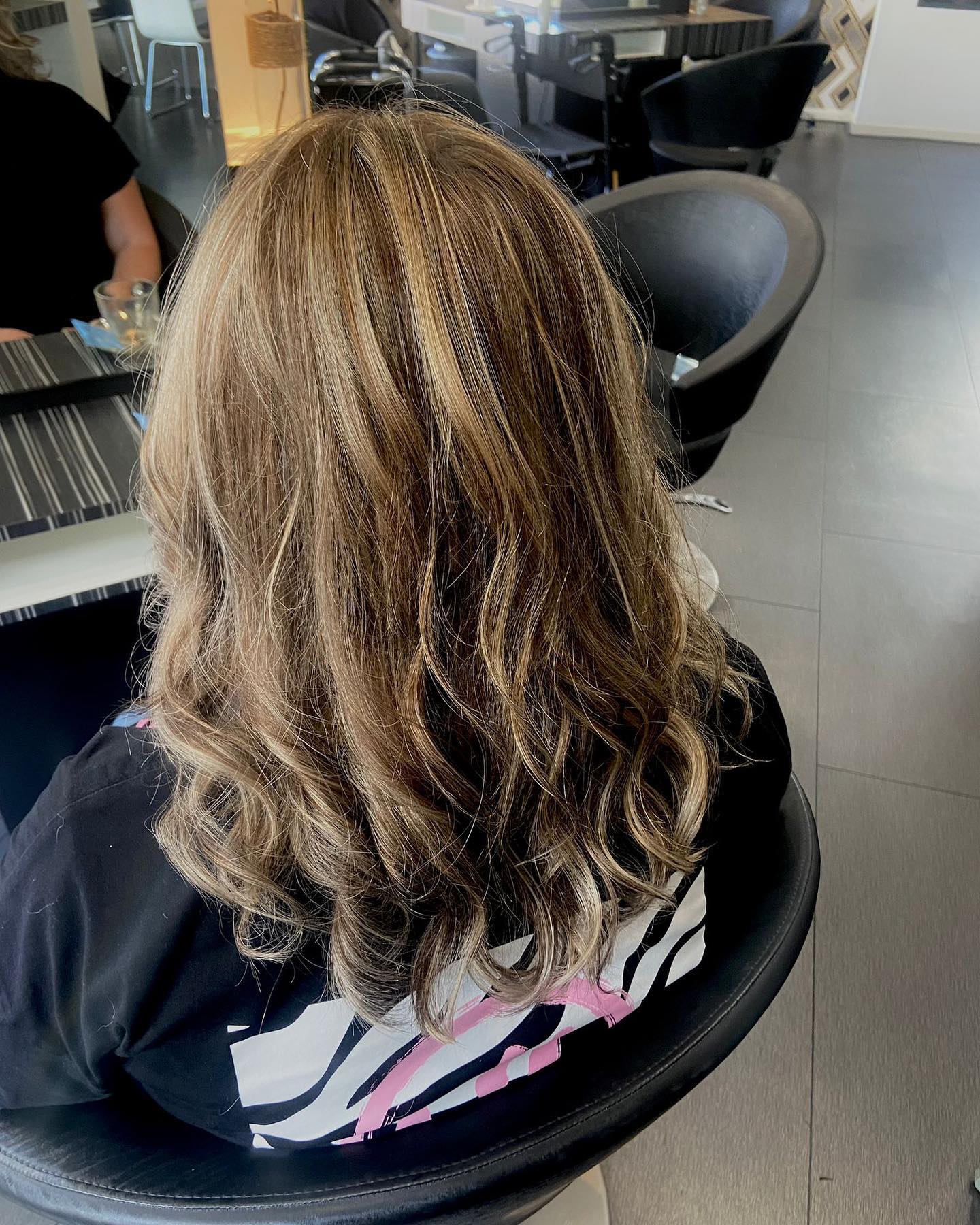 Bruin haar met blonde babylights en losse slagen, in de kappersstoel